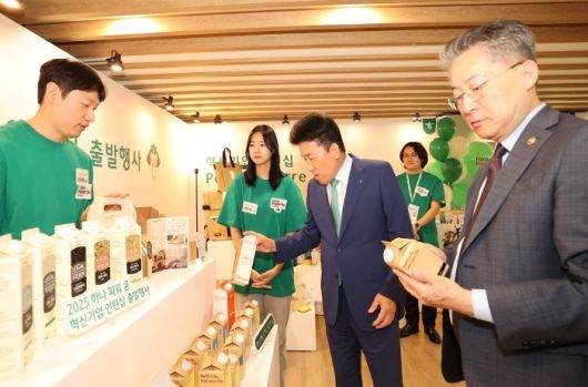 2025 하나파워온 혁신기업 인턴십 출발행사에서 함영주 하나금융그룹 회장(왼쪽 세번째), 김민석 고용노동부 차관(오른쪽)이 행사장에 마련된 사회혁신기업 전시부스를 찾아 기업 소개와 제품에 대한 설명을 듣고 있다. 사진ㅣ하나금융그룹