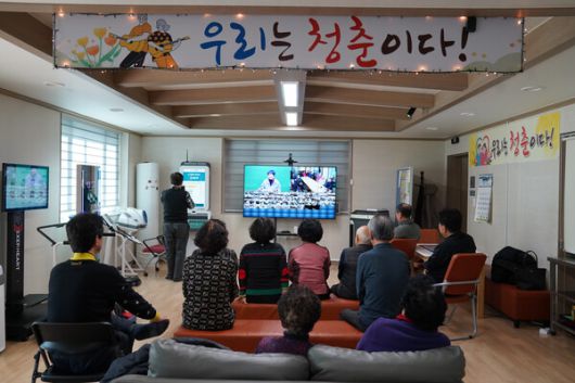 홍천군 스마트경로당. 어르신들이 온라인을 통해 교육을 받고 있고, 왼쪽에 있는 기기들을 통해 건강관리도 가능하다