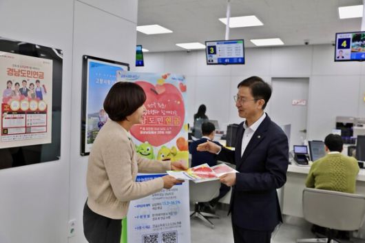 NH농협은행 권동현 경남본부장(오른쪽)이 영업점에 내방한 고객에게 경남도민연금에 대해 설명하고 있다.