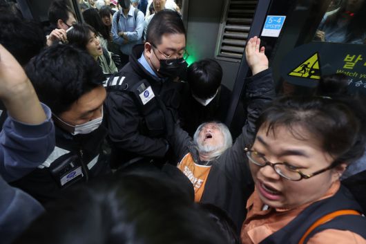 박경석 전국장애인차별철폐연대(전장연) 대표가 지난 21일 서울 지하철 4호선 혜화역에서 제62차 '출근길 지하철 탑니다' 시위를 벌이던 중 이를 저지하던 서울교통공사 관계자와 충돌하며 넘어졌다.