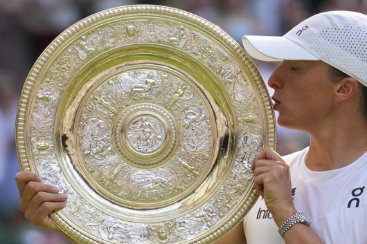 폴란드의 이가 시비옹테크가 2025년 7월 12일(토) 영국 런던에서 열린 윔블던 테니스 선수권 대회 여자 단식 결승전에서 미국의 아만다 아니시모바를 꺾고 우승한 뒤 트로피에 입을 맞추고 있다. (AP 사진/킨 청)