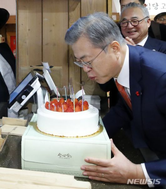 【대전=뉴시스】전신 기자 = 전국경제투어로 대전을 방문한 문재인 대통령이 2019년 1월 24일 대전의 명물 성심당 빵집에서 튀김 소보로를 구매한 후 직원들로부터 받은 깜짝 생일 축하 케이크의 촛불을 끄고 있다. 2019.01.24. photo1006@newsis.com /사진=뉴시스