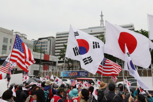윤석열 대통령과 기시다 후미오 일본 총리의 정상회담이 열리는 7일 오후 서울 용산구 대통령 집무실 앞에서 한미동맹강화국민운동본부 회원이 기시다 총리의 방한을 환영하며 태극기와 일장기를 흔들고 있다. 연합뉴스