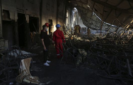 이라크 북부 니네베주 함다니야의 한 결혼식장에서 소방관들이 27일 불꽃놀이로 인한 화재로 완전히 불탄 결혼식장 홀에 대한 잔불 정리를 하고 있다. 26일 밤(현지시간) 발생한 이 화재로 최소 100명이 숨지고 150명이 부상했지만, 신체의 50∼60%에 화상을 입은 중상자들이 많아 사망자 수는 더욱 늘어날 것이 확실시된다. 뉴시스