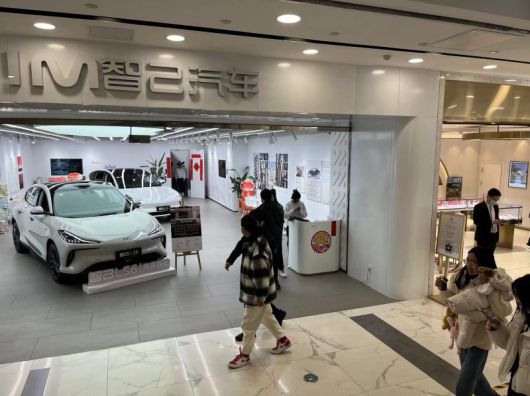 카이더몰 1층 한복판의 귀금속 매장들 옆에 전시된 EV 즈지 모델 매장 앞을 소비자들이 지나고 있는 모습. 사진=이석우 특파원