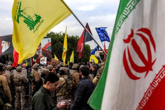 15일(현지시간) 레바논 베이루트의 베이루트 국제공항 인근에서 이란 국기(오른쪽)와 레바논 무장정파 헤즈볼라의 깃발을 든 시위대가 현지 군경과 대치하고 있다.AFP연합뉴스