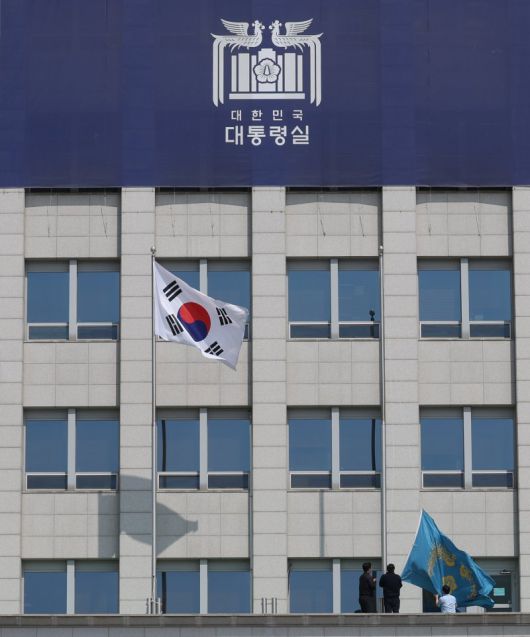 헌법재판소가 윤석열 대통령의 탄핵사건에 대해 인용을 선고한 4일 서울 용산 대통령실 청사에서 관계자들이 봉황기를 하기하고 있다./사진=뉴시스