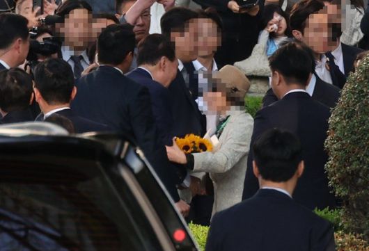 윤석열 전 대통령이 지난 11일 오후 서울 서초구 서초동 자택 앞에서 지지자들에게 꽃다발을 받으며 인사를 나누고 있다. /사진=뉴스1