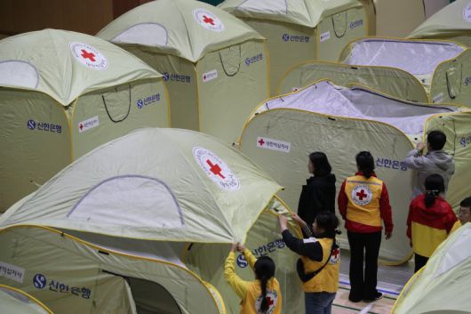 26일 오후 강원 인제군 기린면 기린실내체육관에서 자원봉사자들이 산불 주민 대피소를 설치하고 있다. 이날 오후 1시 18분쯤 인근 야산에서 불이 나 진화 작업이 이어지고 있다. 연합뉴스