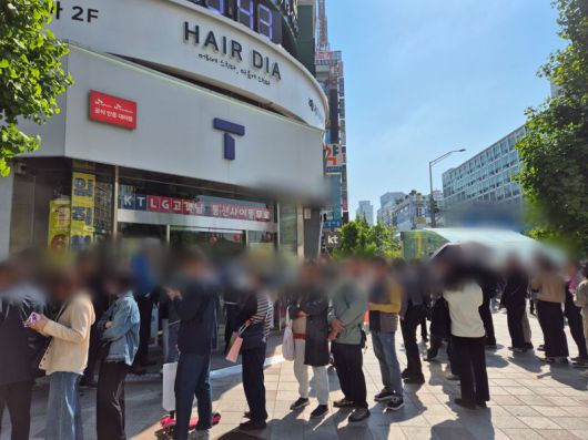 28일 오전 한 SKT 대리점 앞에 유심 무료교체 서비스를 받으러 온 가입자들이 줄을 서고 있다. 줄 곳곳에서 실랑이가 벌어지고, 한 가입자는 "SKT 벌받아야 한다"며 분통을 터뜨리기도 했다. 사진=김예지 기자