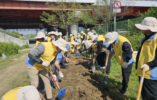 OCI홀딩스 임직원들이 지난 26일 서울 이촌한강공원 내 조성 중인 OCI숲에서 나무를 심고 있다. OCI홀딩스 제공