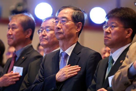 한덕수 대통령 권한대행 국무총리가 29일 서울 강남구 건설회관에서 열린 해외건설 1조달러 수주 및 60주년 기념식에서 국기에 경례하고 있다. /사진=뉴시스화상