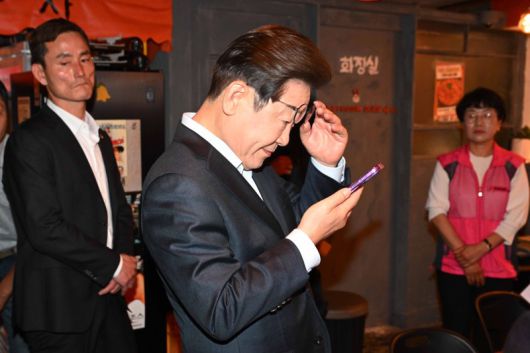 더불어민주당 이재명 대선 후보가 1일 서울 종로구의 한 포차 식당에서 '당신의 하루를 만드는, 보이지 않는 영웅들'이란 주제로 배달 라이더, 택배 기사 등 비(非)전형 노동자들과 간담회를 마친 뒤 휴대전화를 확인하고 있다. 사진=연합뉴스