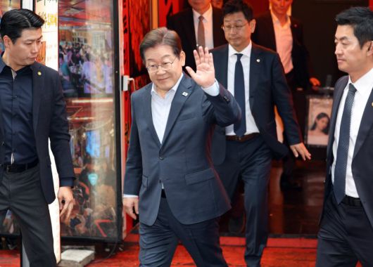 더불어민주당 이재명 대선 후보가 1일 서울 종로구의 한 포차 식당에서 '당신의 하루를 만드는, 보이지 않는 영웅들'이란 주제로 열린 배달 라이더, 택배 기사 등 비(非)전형 노동자들과 간담회를 마친 뒤 나서며 손인사를 하고 있다. 사진=연합뉴스