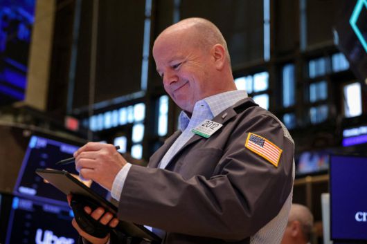 12일(현지시간) 미국 뉴욕의 뉴욕증권거래소(NYSE)에서 한 중개인이 미소짓고 있다. 로이터연합뉴스