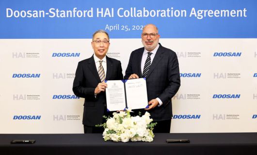 박지원 두산그룹 부회장(왼쪽)이 지난달 25일 동대문 두산타워에서 열린 산학협력 협약식에서 제임스 랜데이 스탠포드대 HAI연구소 공동연구소장과 기념촬영을 하고 있다. 두산그룹 제공