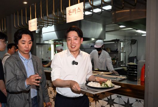 이준석 개혁신당 대선 후보가 지난 13일 대구 북구 경북대학교를 찾아 학생식당에서 주문한 돈가스를 받고 있다. 공동취재