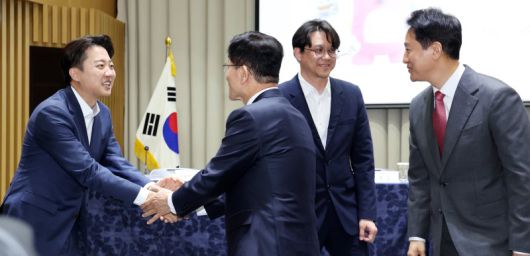 오세훈 서울시장(오른쪽 첫 번째)이 19일 오전 서울 중구 서울시청에서 열린 '약자와 동행하는 서울 토론회'에서 이준석 개혁신당 대통령 후보(왼쪽 첫 번째)와 김문수 국민의힘 대통령 후보가 악수를 나누는 모습을 지켜보고 있다. 뉴스1