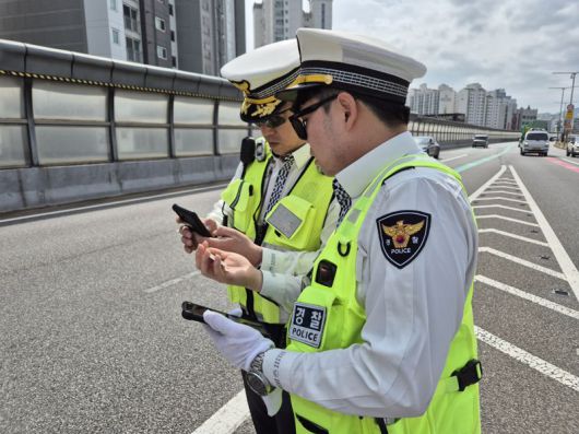 내부순환로 성수 방면 북부간선로 분기점에서 운전 중 휴대전화를 사용한 운전자에게 '교통 위반 딱지'를 부과하는 모습. 사진=공동취재단