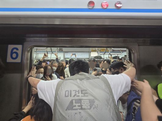 21일 오전 전국장애인차별철폐연대(전장연)가 출근길 지하철 탑승 시위를 열고 있다. 시위대가 추가 탑승을 위해 출입문이 닫히지 않도록 양손으로 문을 잡으며 실랑이가 벌어졌다. 대치가 계속된 탓에 출입문은 닫혔다 열리기를 반복했다. /사진=서지윤 기자