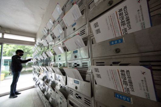 지난 24일 경기 수원시의 한 아파트 단지의 우편함에 제21대 대선 관련 투표 안내문 및 전단형 선거공보물이 도착한 가운데 한 주민이 이를 살펴보고 있다.뉴스1