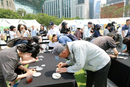 행사를 방문한 시민들이 달고나 뽑기 이벤트에 열중하고 있다. 사진=서동일 기자