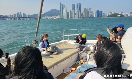 30일 오후 부산 해운대 더베이 101에서 진행된 ‘요트 리트릿’ 프로그램 현장. 핸드팬 아티스트 안유진씨(맨 뒤)가 요트 선상에서 핸드팬 연주를 선보이고 있다. 사진=변옥환 기자