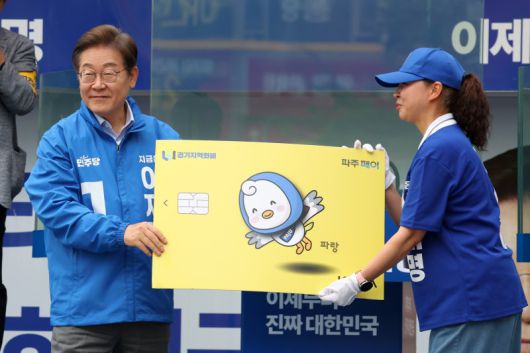 이재명 더불어민주당 대선후보가 지난 20일 경기 파주시 금릉역 중앙광장에서 열린 유세에서 선거운동원으로부터 경기지역화폐 파주페이 모형을 받고 있다. /사진=뉴시스화상
