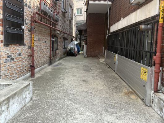 서울 동작구 상도역 2번 출구 인근 반지하 골목에서 물막이판이 설치된 건물(오른쪽)과 물막이판 없이 방범창만 설치된 건물(왼쪽)의 모습. 사진=이현정 기자