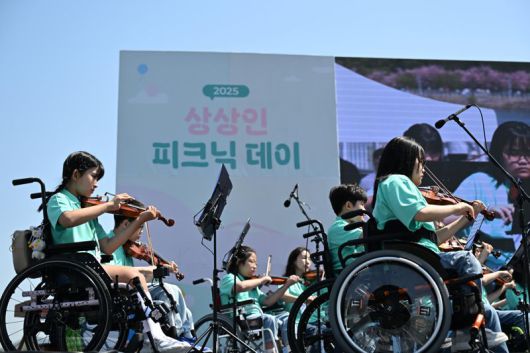 상상인그룹이 지난 26일 경기도 하남 미사경정공원에서 개최한 ‘2025 상상인 피크닉데이’에서 ‘상상휠하모니 오케스트라’가 축하 공연을 하고 있다. 상상인그룹 제공