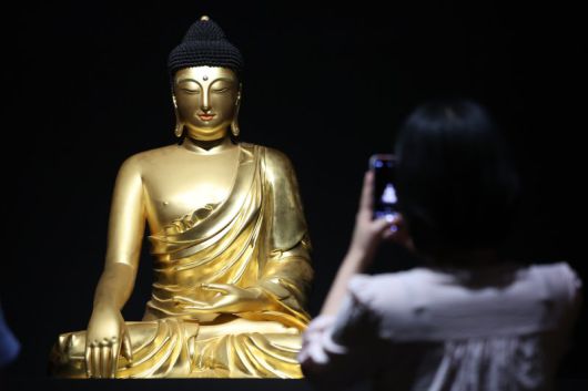 서울 용산구 국립중앙박물관에서 열린 '새 나라 새 미술:조선 전기 미술 대전' 특별전에서 관람객이 조계사 목조여래좌상을 살펴보고 있다. 뉴스1