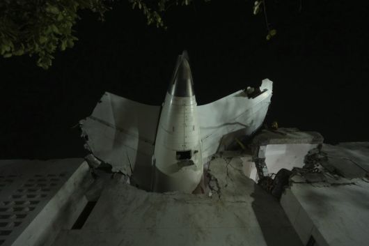 12일(현지 시간) 인도 구자라트주 아마다바드에서 발생한 여객기 추락 사고 현장에 비행기 꼬리 부분이 건물에 박혀 있다. 뉴시