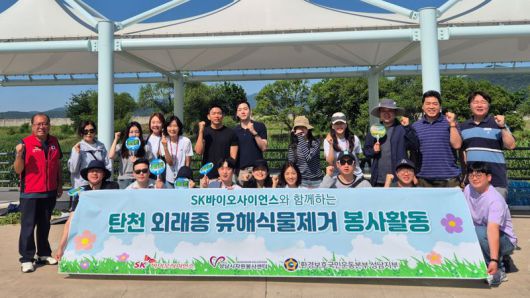 SK바이오사이언스 임직원들이 성남시 탄천 일대에서 외래종 유해식물 제거 활동에 앞서 기념사진을 찍고 있다. SK바이오사이언스 제공