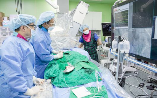 부산대병원 순환기내과 최정현(왼쪽부터) 이한철 교수 등 타비 시술팀이 경피적 대동맥판막삽입술(TAVI)을 시행하고 있다. 부산대병원 제공