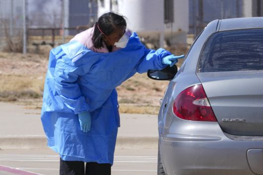 미국 텍사스주 세미놀 병원 주차장에서 2월 21일(현지시간) 방역복을 입은 의료진이 홍역 검사를 하기 전 차에 탄 이들을 상대로 문진하고 있다. AP 뉴시스