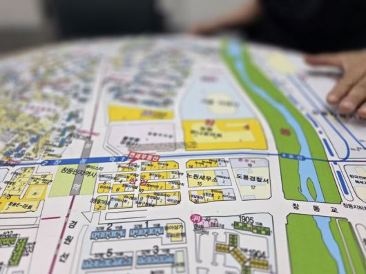 지난 19일 도봉구 창동역 인근 부동산 중개업소 관계자가 창동 차량기지 일대 개발 예정지를 가리키고 있다. 사진=장인서 기자