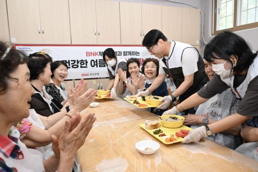 초복을 하루 앞둔 지난 19일 방성빈 BNK부산은행장(오른쪽 세번째)이 은행 '두근두근 지역봉사단' 단원들과 함께 지역 어르신들에게 일일히 삼계탕을 전달하며 대접하고 있다. BNK부산은행 제공