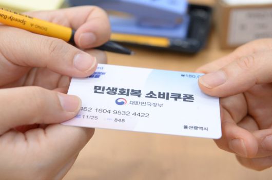 [울산=뉴시스] 배병수 기자 = 민생회복 소비쿠폰 1차 지급을 실시하는 21일 오전 울산 남구 신정1동 행정복지센터 2층 대강당에 마련된 접수 창구에서 한 시민이 민생회복 소비쿠폰 카드를 발급받고 있다. 2025.07.21.bbs@newsis.com. <저작권자ⓒ 공감언론 뉴시스통신사. 무단전재-재배포 금지.> /사진=뉴시스화상