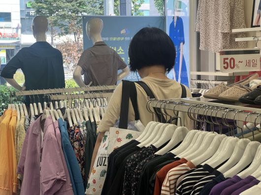 지난 25일 민생회복 소비쿠폰 사용처인 서울의 한 의류매장에서 여성 고객이 매장을 둘러보고 있다. 사진=김현지 기자                                     27일 롯데마트 제타플렉스 서울역점 매장 입구에 민생회복 소비쿠폰 사용처를 알리는 안내문이 게시돼 있다. 연합뉴스