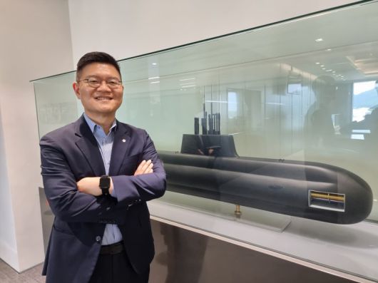 이경길 한화오션 특수선해외사업단 특수선해외영업1팀 팀장(상무)이 5일 한화오션 남대문사무소에 전시된 '장보고-III 배치-II' 모형 앞에서 포즈를 취하고 있다. 사진=김동호 기자