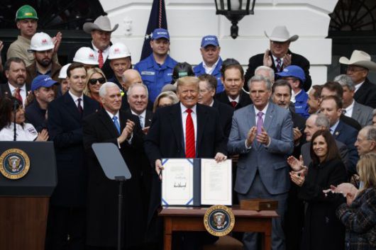 미국의 도널드 트럼프 대통령(가운데)이 2020년 1월 29일 미국 워싱턴DC 백악관에서 기존 북미자유무역협정(NAFTA)을 대체하는 새로운 미국·멕시코·캐나다협정(USMCA)에 서명한 뒤 이를 들어 보이고 있다.AP뉴시스