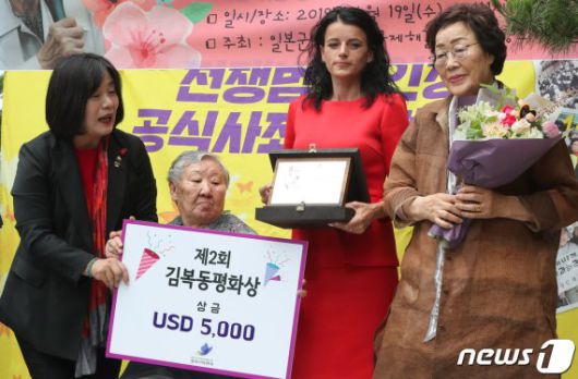 2019년 6월 19일 서울 종로구 옛 일본대사관 앞에서 열린 제1392차 일본군 성노예제 문제 해결을 위한 정기 수요시위에서 코소보 내전 생존자인 바스피예 크라스니치-굿맨이 '제2회 김복동평화상'을 수상하고 있다. 왼쪽부터 윤미향 당시 정의연 상임대표, 위안부 피해자 길원옥, 바스피예 크라스니치-굿맨, 이용수 할머니. © News1 /사진=뉴스1