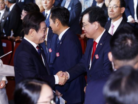 이재명 대통령이 15일 서울 세종문화회관에서 열린 80주년 광복절 경축식에서 국민의힘 송언석 비상대책위원장 겸 원내대표와 인사하고 있다. [대통령실통신사진기자단] 연합뉴스