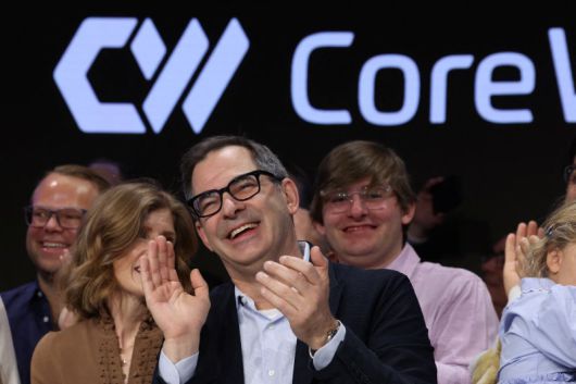 인공지능(AI) 데이터센터 업체 코어위브 창업자이자 최고경영자(CEO)인 마이클 인트레이터(가운데)가 3월 28일(현지시간) 미국 뉴욕 나스닥 거래소에서 코어위브 첫 거래를 알리는 타종 뒤 박수를 치고 있다. 로이터 연합