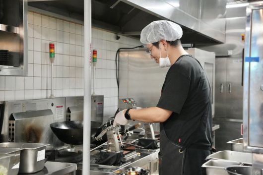 한 주방직원이 만다린로보틱스가 제작한 요리봇들로 음식을 만들고 있다. 만다린로보틱스 제공