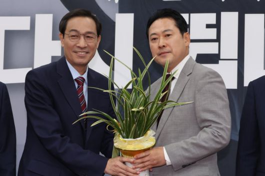 우상호 대통령실 정무수석이 27일 서울 여의도 국회에서 국민의힘 장동혁 신임 대표를 예방해 이재명 대통령이 보낸 축하난을 전달하고 있다. 연합뉴스