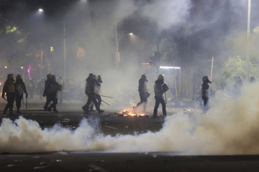 인도네시아 경찰이 30일 동부 자바 수라바야에서 최루탄을 터뜨리며 시위를 진압하고 있다. AP 뉴시스