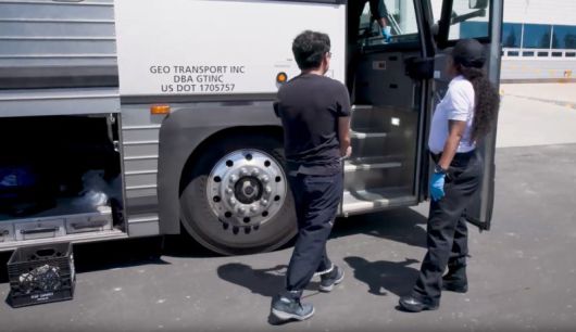 미국 이민세관단속국에 의해 체포된 한국인 직원이 손발이 묶인채로 소송차에 올라 타고 있다. 뉴스1