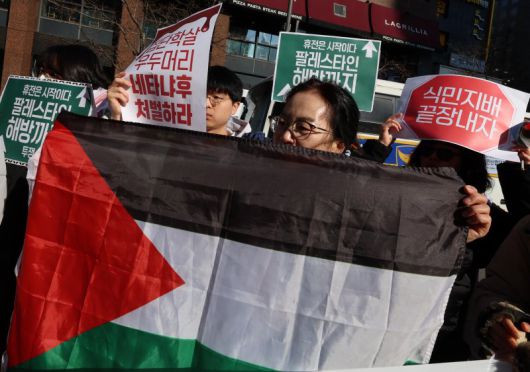 지난 17일 주한이스라엘대사관 앞에서 열린 가자지구의 영구적 휴전 및 식민 지배 종식 촉구 긴급 기자회견에서 한 참석자가 팔레스타인 국기를 들고 있다. 뉴시스