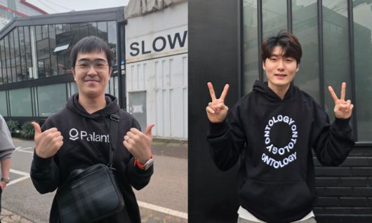 팔란티어 로고가 그려진 후드티를 입고 현장을 방문한 소프트웨어 엔지니어 권민철씨(왼쪽)와 다섯 시간을 기다려 산 후드티를 입고 사진을 찍어 준 권동재씨. 감사합니다. 사진=성민서 기자